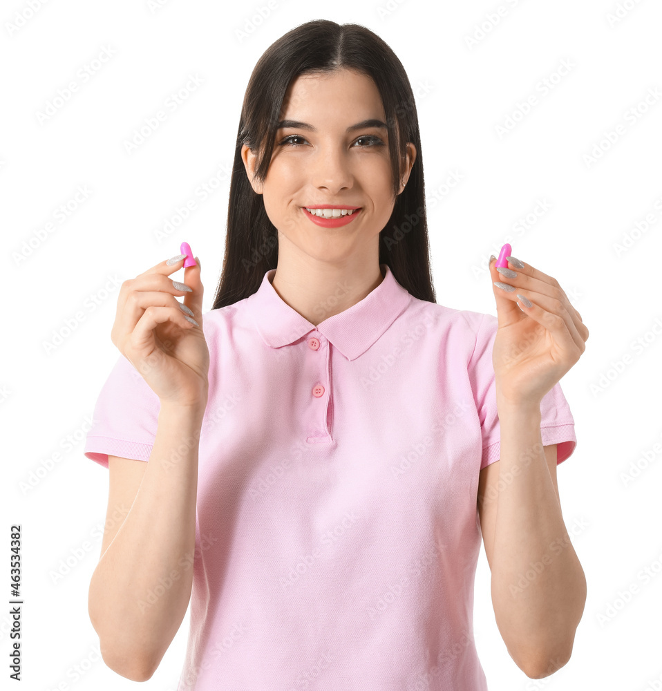 Pretty young woman with pink ear plugs on white background