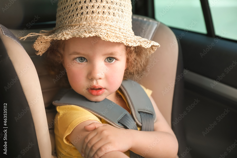 Cute little girl buckled in car safety seat, closeup