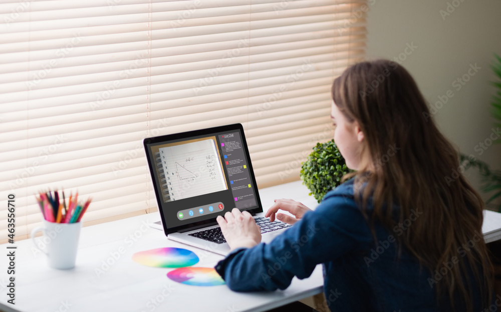 Caucasian girl using laptop for video call, with class on screen