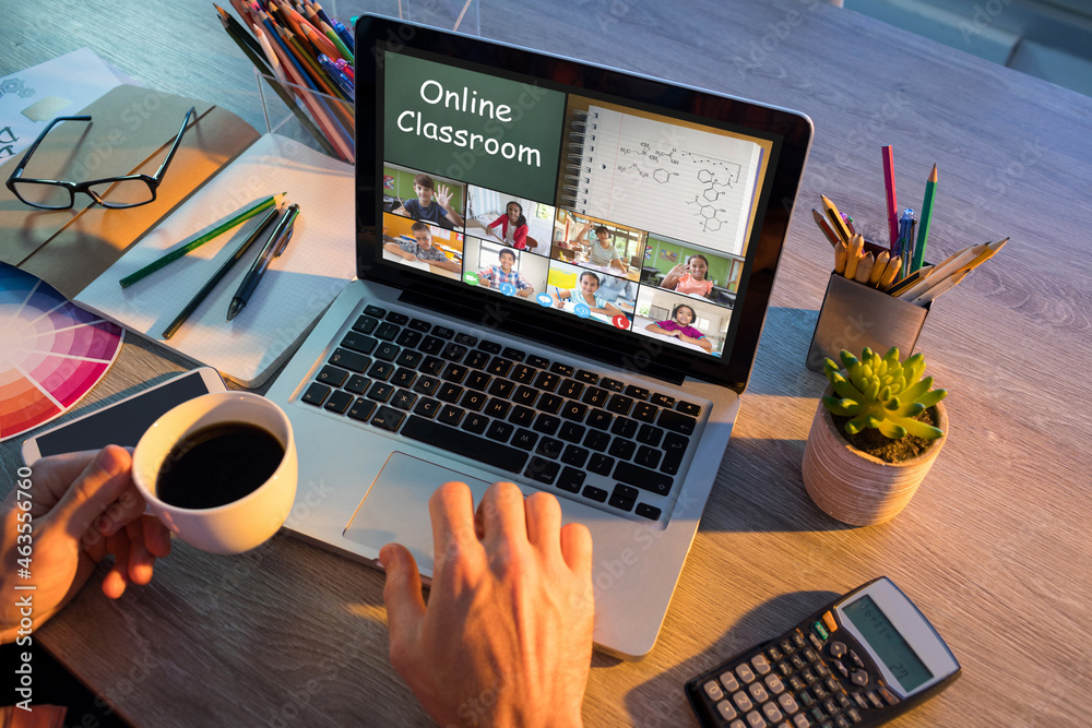 Hands of man using laptop for video call, with smiling diverse elementary school pupils on screen