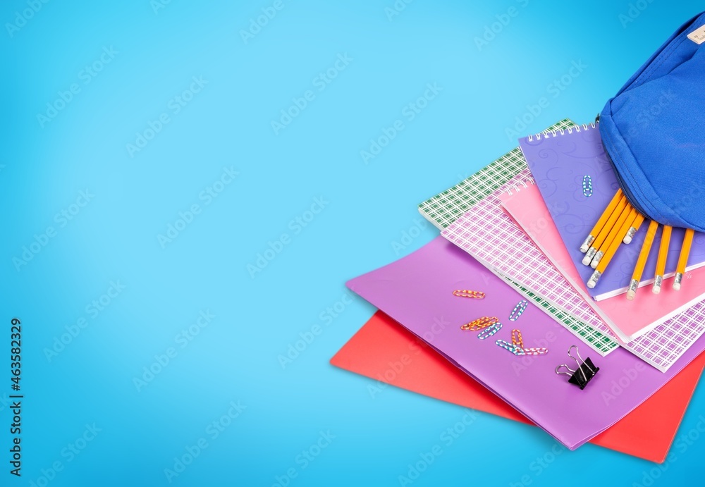 Modern backpack with school stationery over table background, back to school design concept.