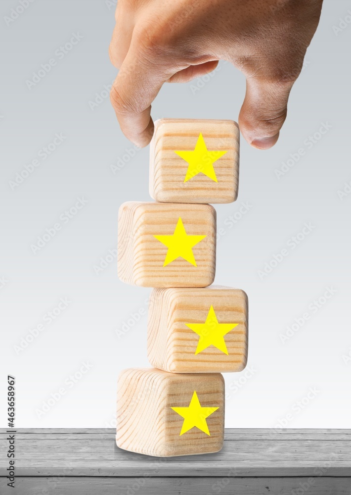 Hand holding wooden blocks with the star symbol. Customer reviews, feedback, ranking and service con