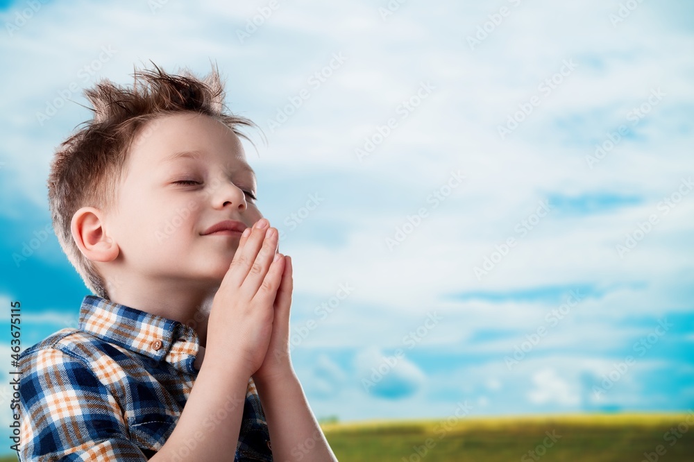 little child praying to God with hands together and a smile