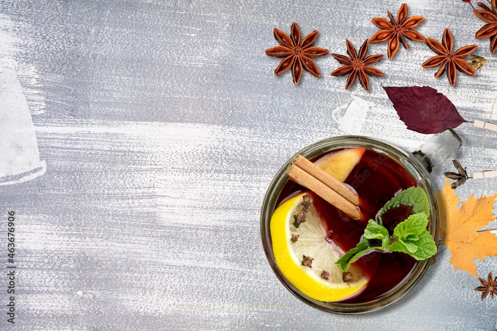 Hot tea or coffee with fall foliage, cinnamon sticks and star anise. Colorful autumn leaves