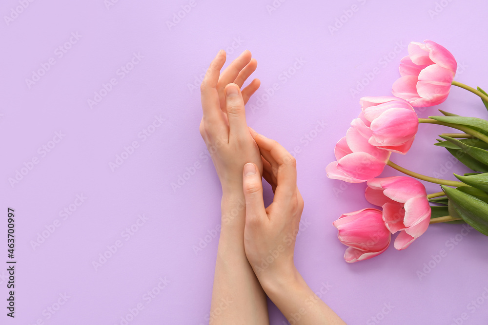 Female hands with flowers on color background