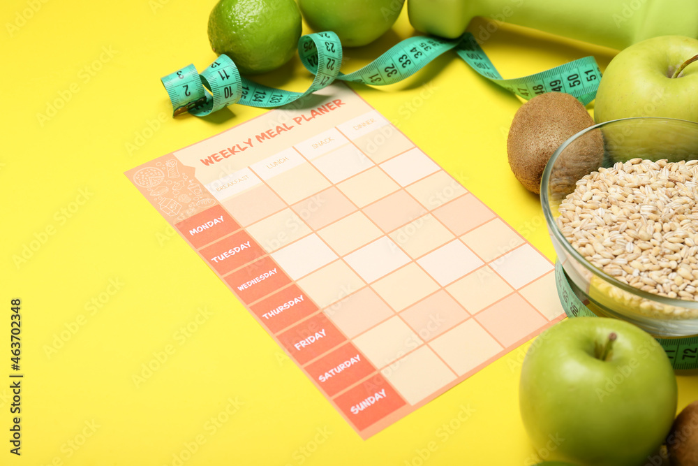 Healthy products, meal plan, dumbbell and measuring tape on color background