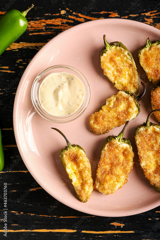 Plate with tasty jalapeno poppers on dark wooden background