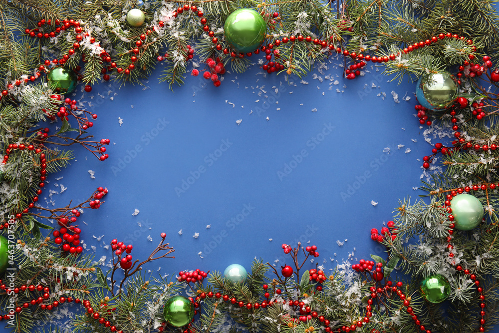 Frame made of fir branches and Christmas decorations on blue background, closeup