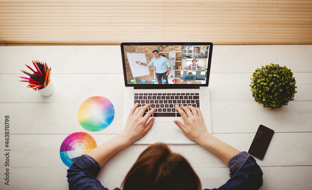 Caucasian woman using laptop for video call, with smiling diverse high school pupils on screen