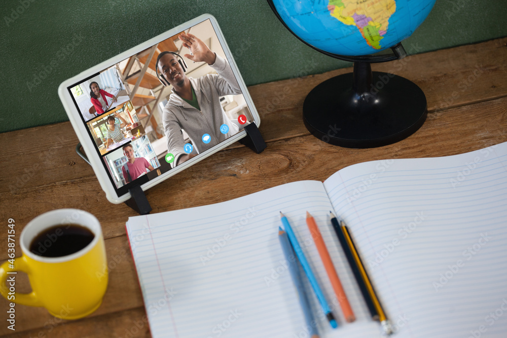 Smiling diverse high school pupils and male teacher during class on tablet screen