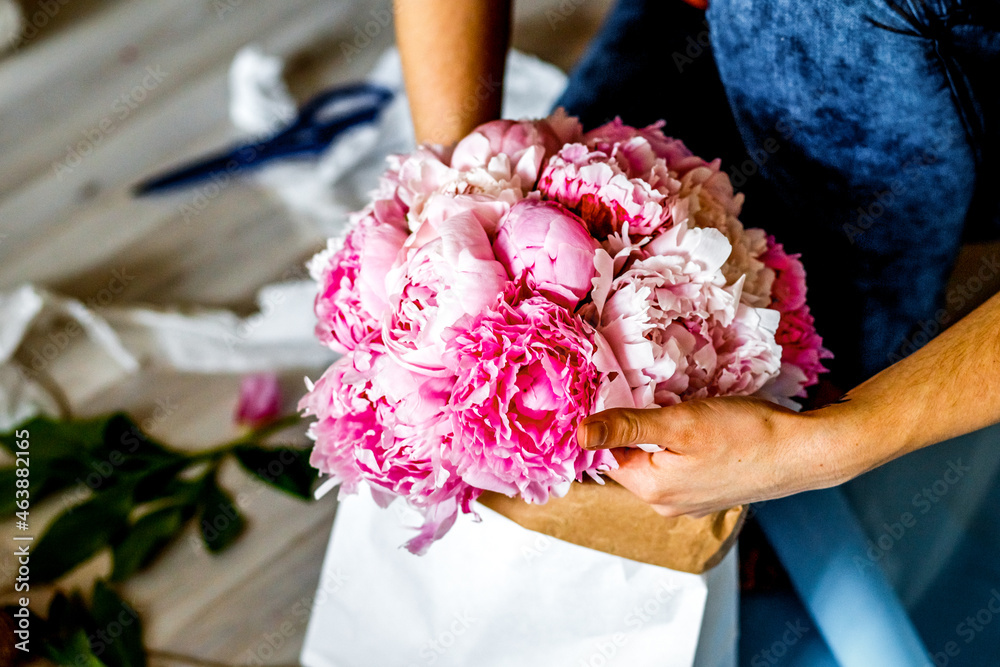 Florist making a bouguet of peonies at workshop