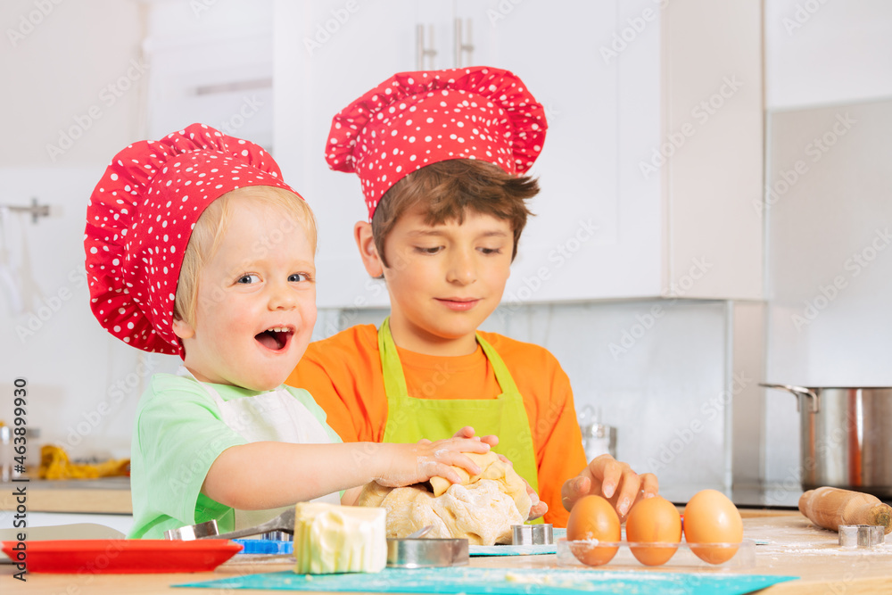 Brothers crumble dough with hands in chef hats