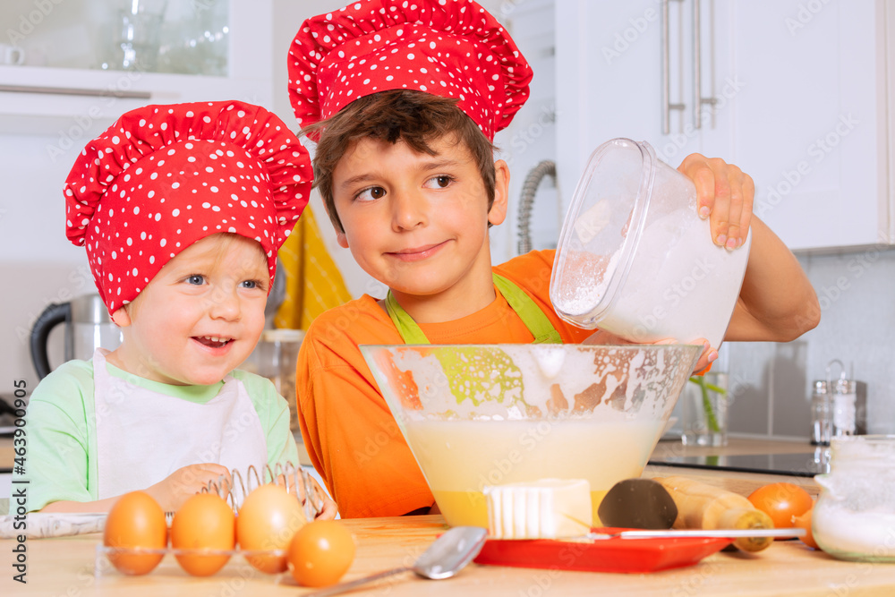 Boy pour flour to the mixing bowl cooking cookies