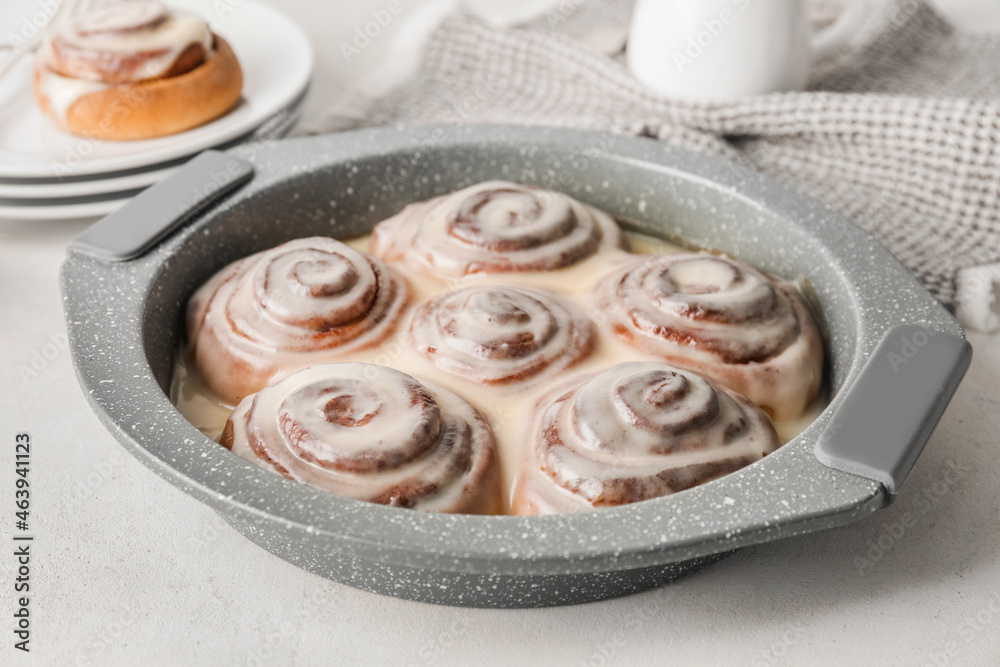 Baking dish with tasty cinnamon rolls on table