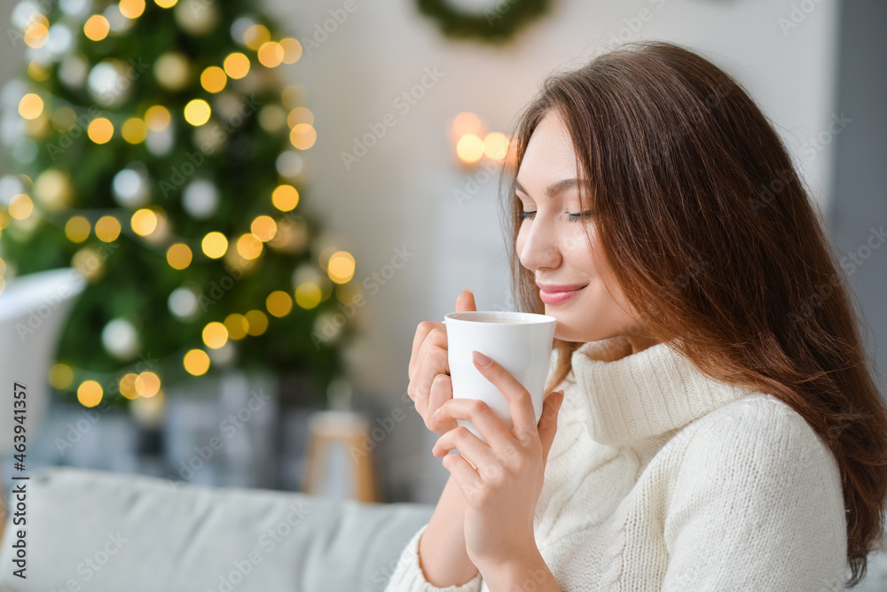 圣诞节前夕，家里有一杯热可可饮料的漂亮年轻女人