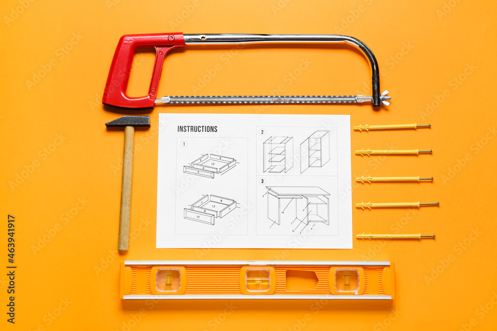 家具组装说明、悍马、钢锯、建筑水平仪、销钉和橙色背面的螺钉