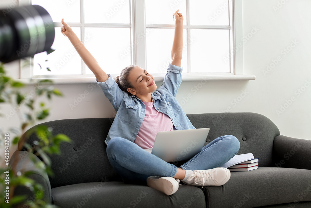 Happy female student preparing for exam at home