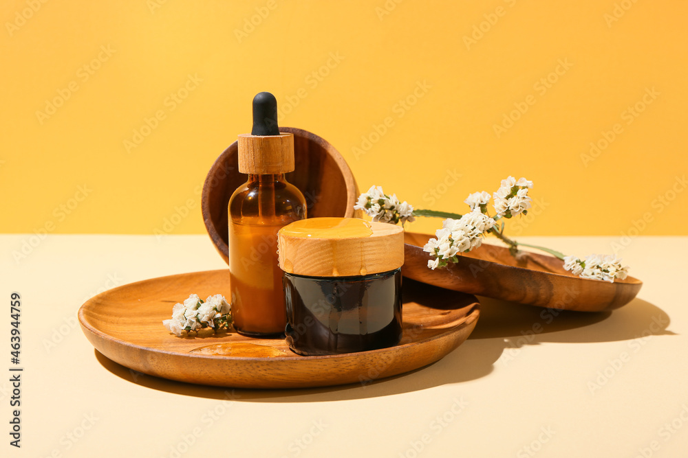 Composition with cosmetic products, flowers and honey on color background