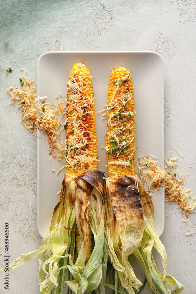 Plate with delicious Elote Mexican Street Corn on light background