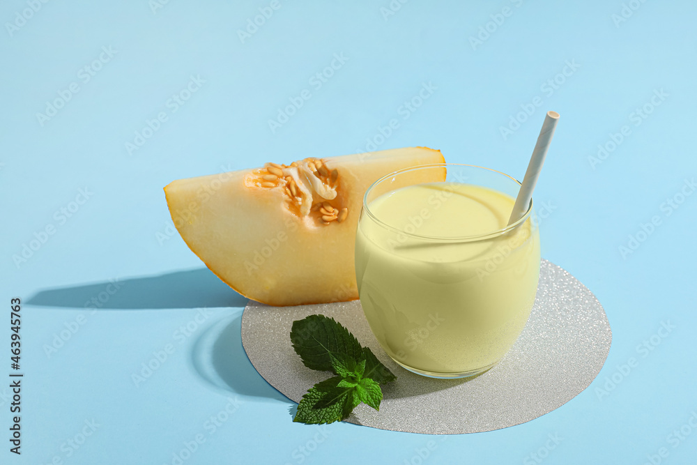 Glass of tasty melon milkshake on color background