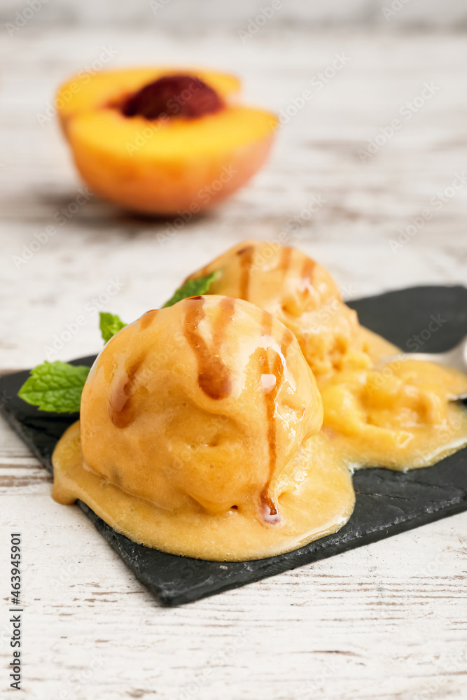 Board of tasty peach ice cream on white wooden background