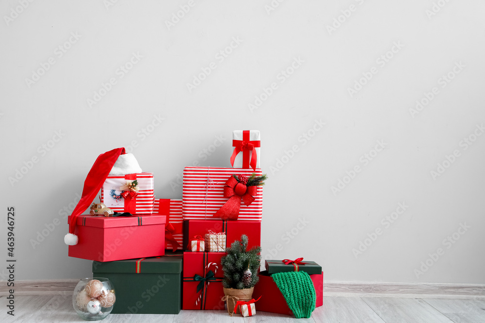 Beautiful Christmas gifts near light wall