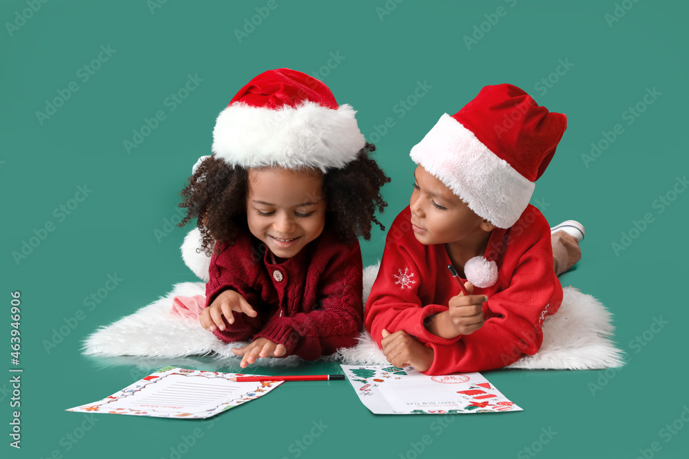 Cute African-American children writing letters to Santa on color background