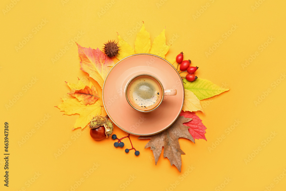 Composition with cup of coffee and autumn leaves on yellow background