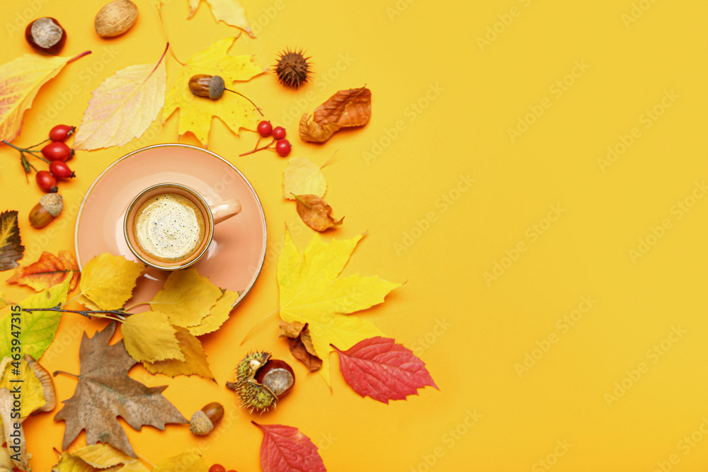 Composition with cup of coffee and autumn leaves on yellow background