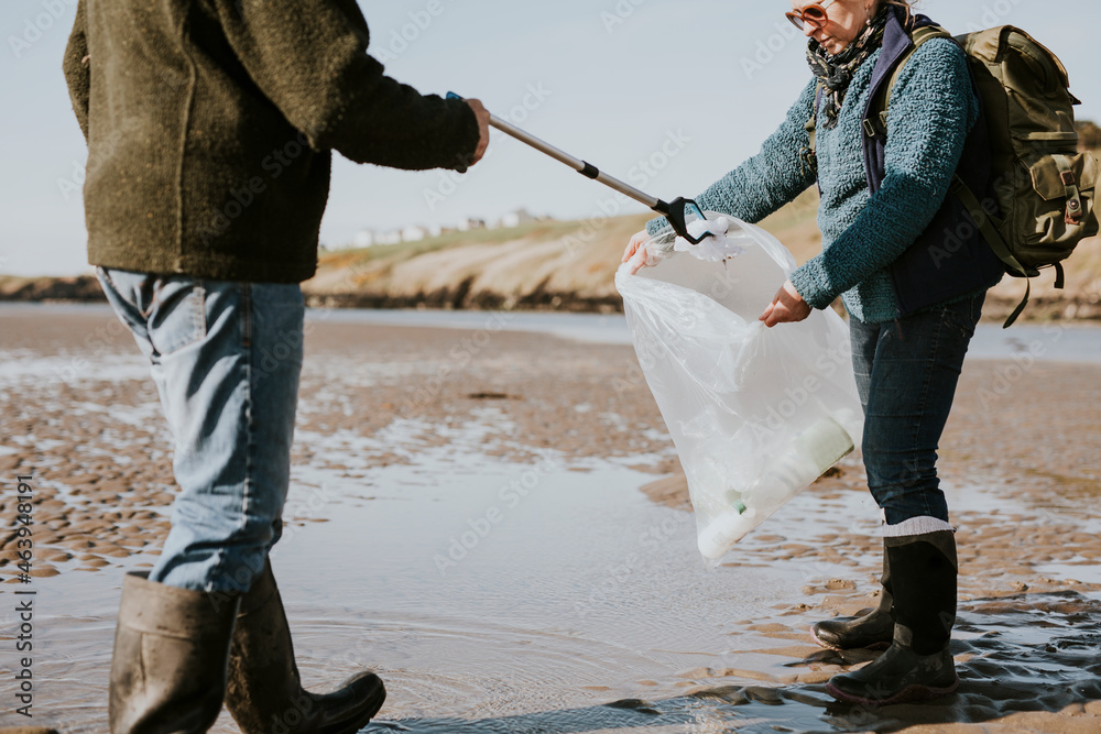 Beach cleanup volunteers picking up trash for environment campaign