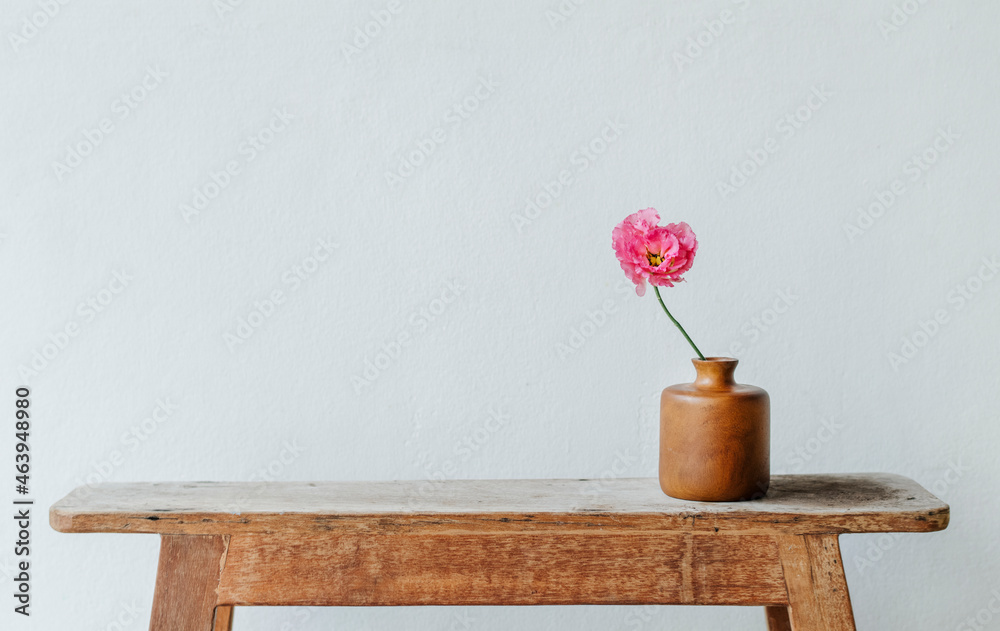 Pink peony in a vase by the wall