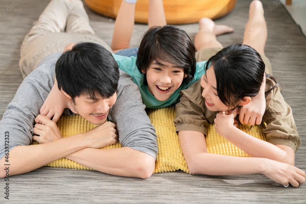 Family at home relaxing on carpet,asian family married couple little adorable son lying at cushion o