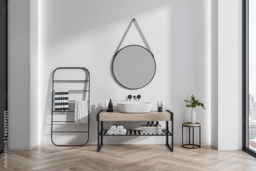 Modern bathroom interior with wooden flooring, drying rack, mirror and wash basin. Design and interi