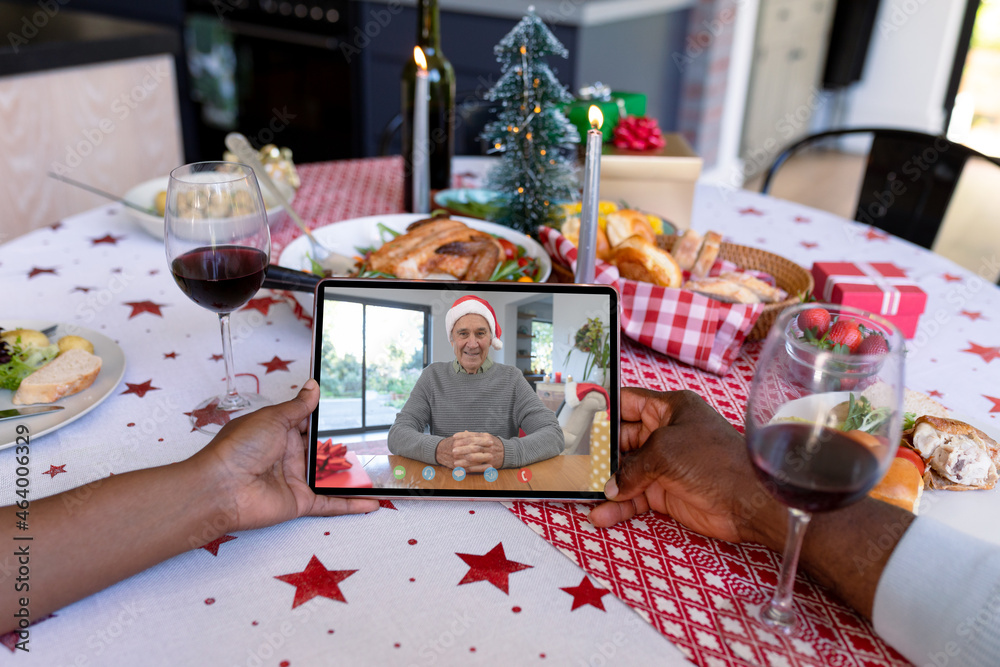 African american couple on tablet christmas video call with smiling male friend