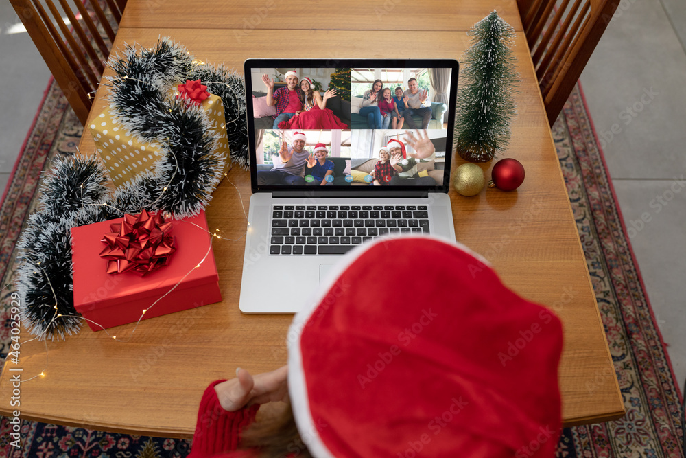 Caucasian woman in santa hat on laptop christmas video call with smiling friends