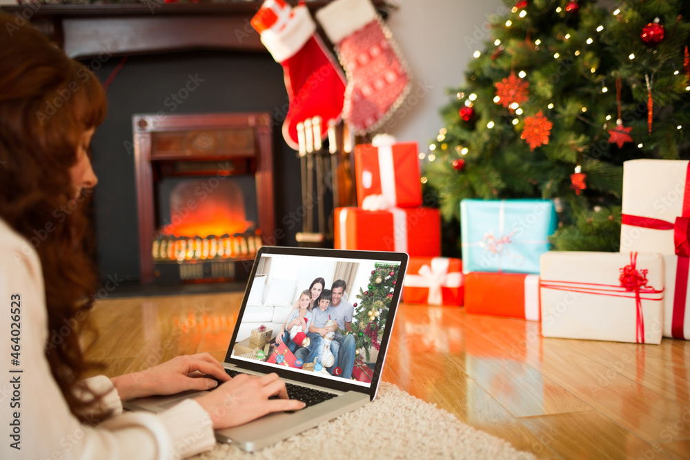 Caucasian woman making laptop christmas video call with smiling family