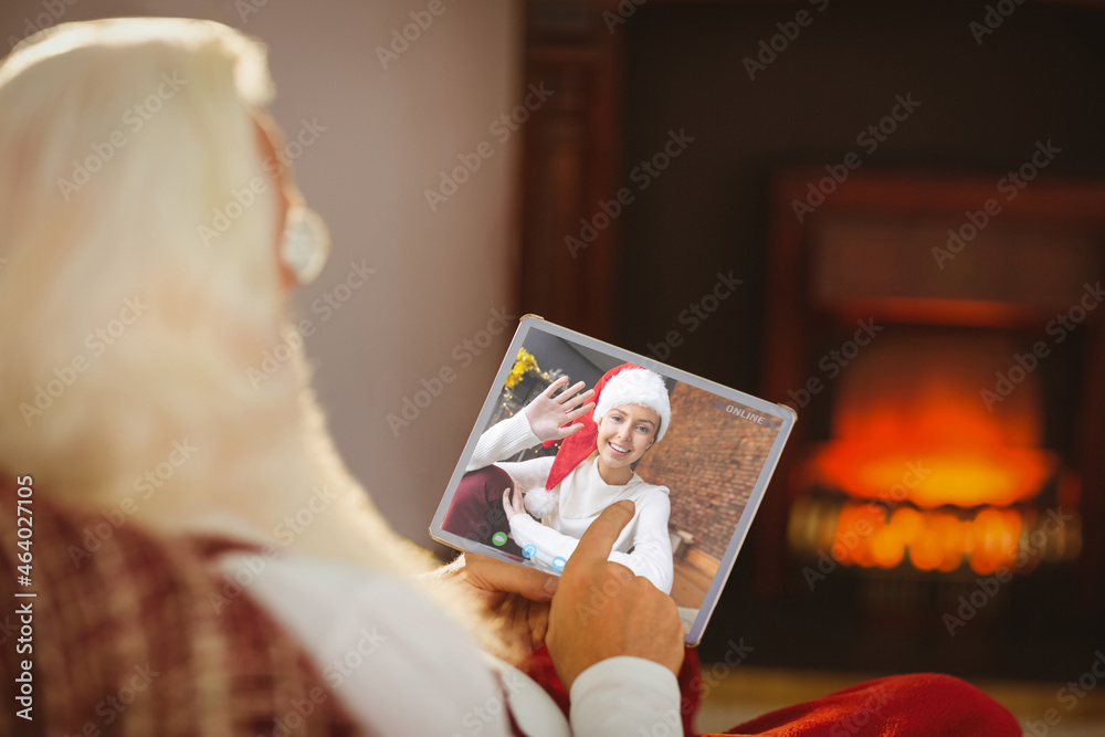 Caucasian santa claus on christmas laptop video call with caucasian woman