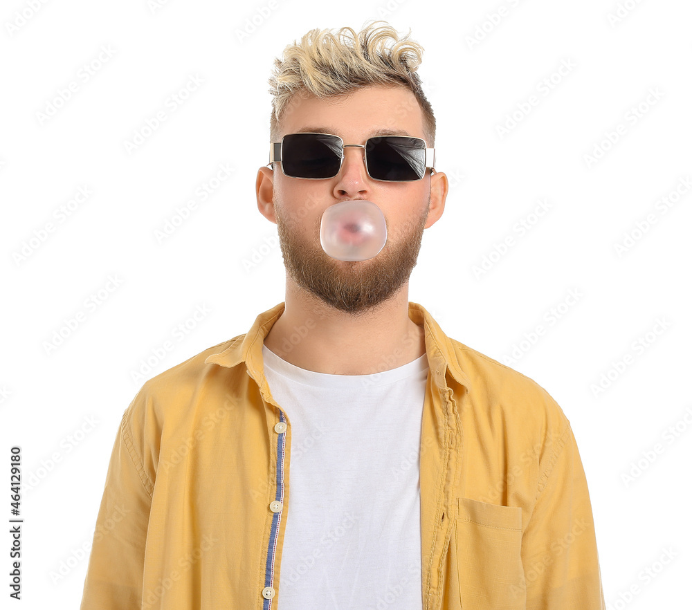 Cool young man with chewing gum on white background