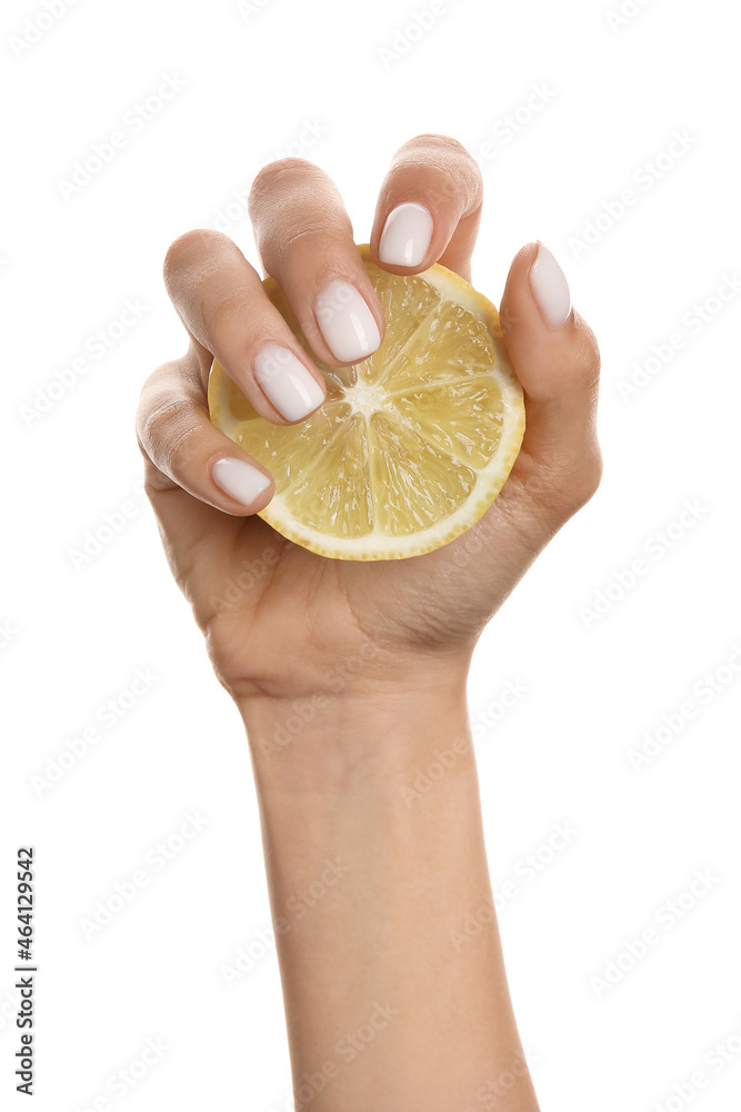 Woman with beautiful manicure holding sliced lemon on white background