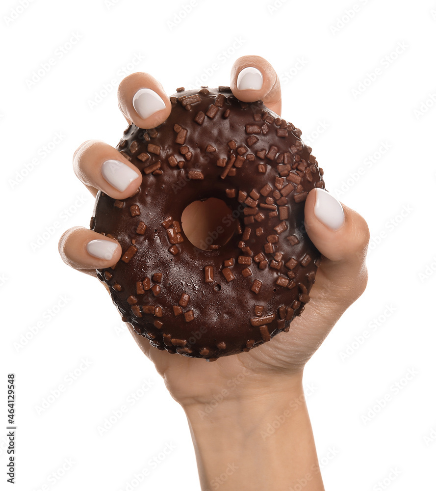 Woman with beautiful manicure holding delicious chocolate doughnut on white background