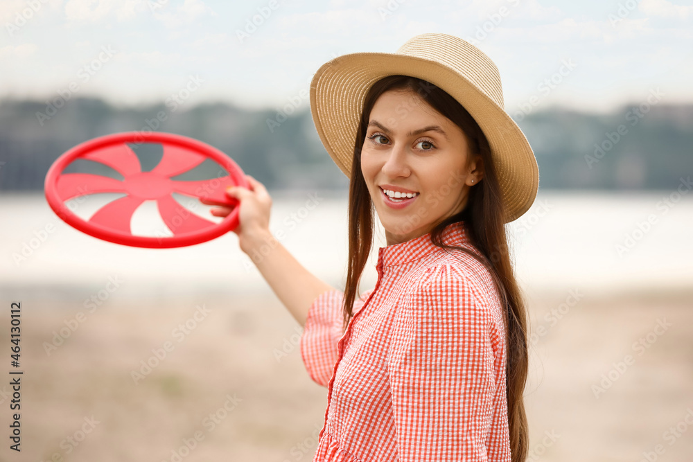 美丽的年轻女子在户外玩飞盘