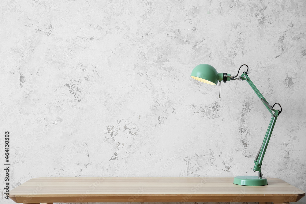 Green lamp on table near light wall