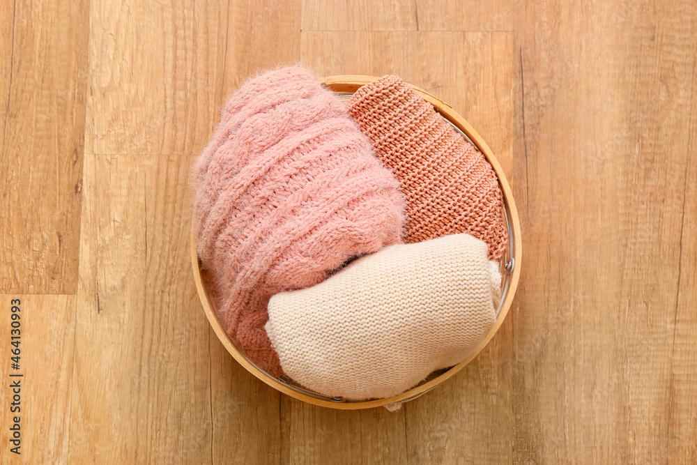 Basket with clothes on wooden background