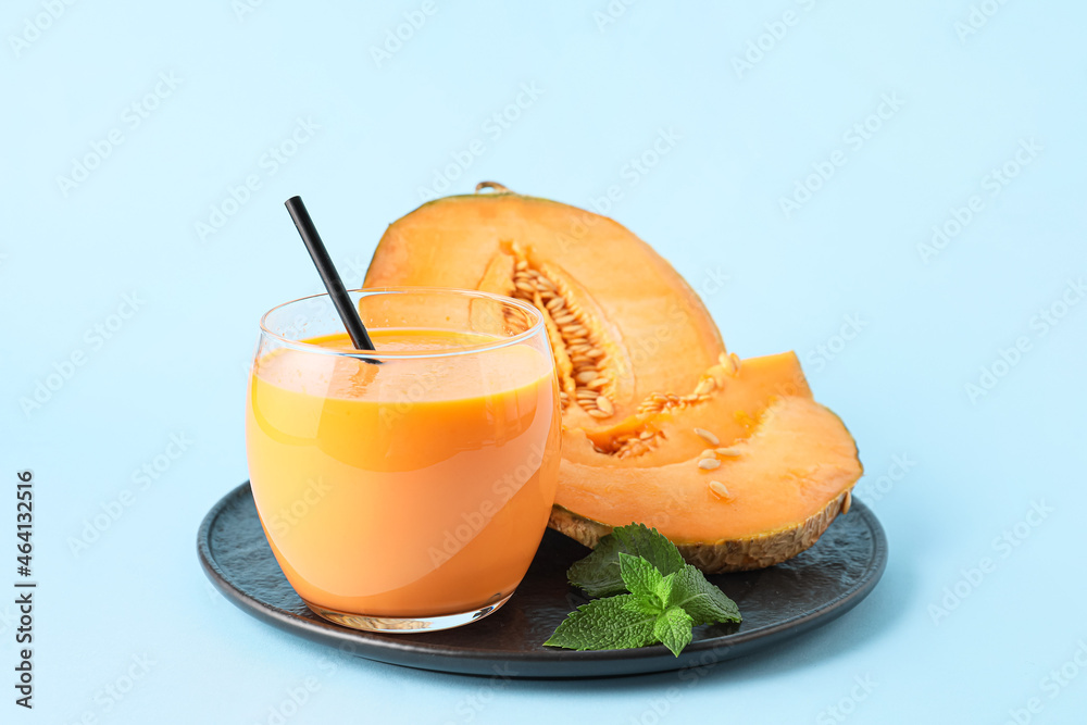 Glass of tasty melon milkshake on color background