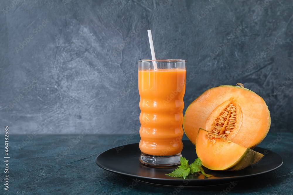 Glass of tasty melon milkshake on dark background