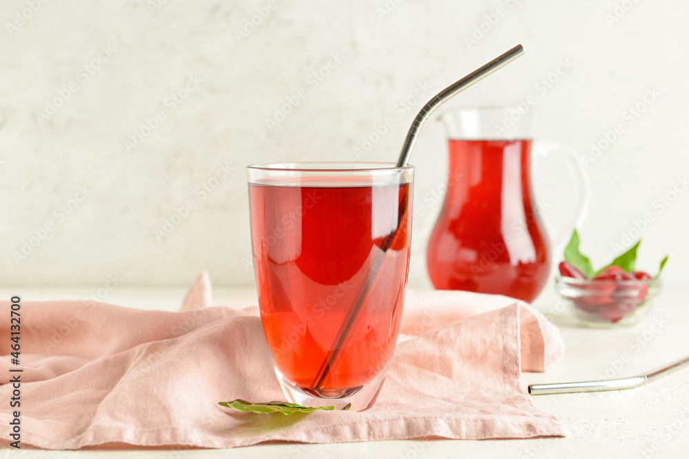 Glass of healthy dogwood berry drink on light background