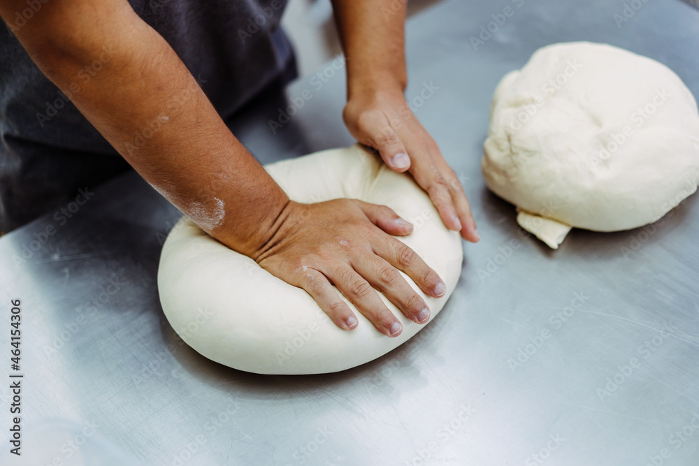 Man preparing bread dough on table in a bakery factory.Dough ball for croissant bakery.pizza, bakery