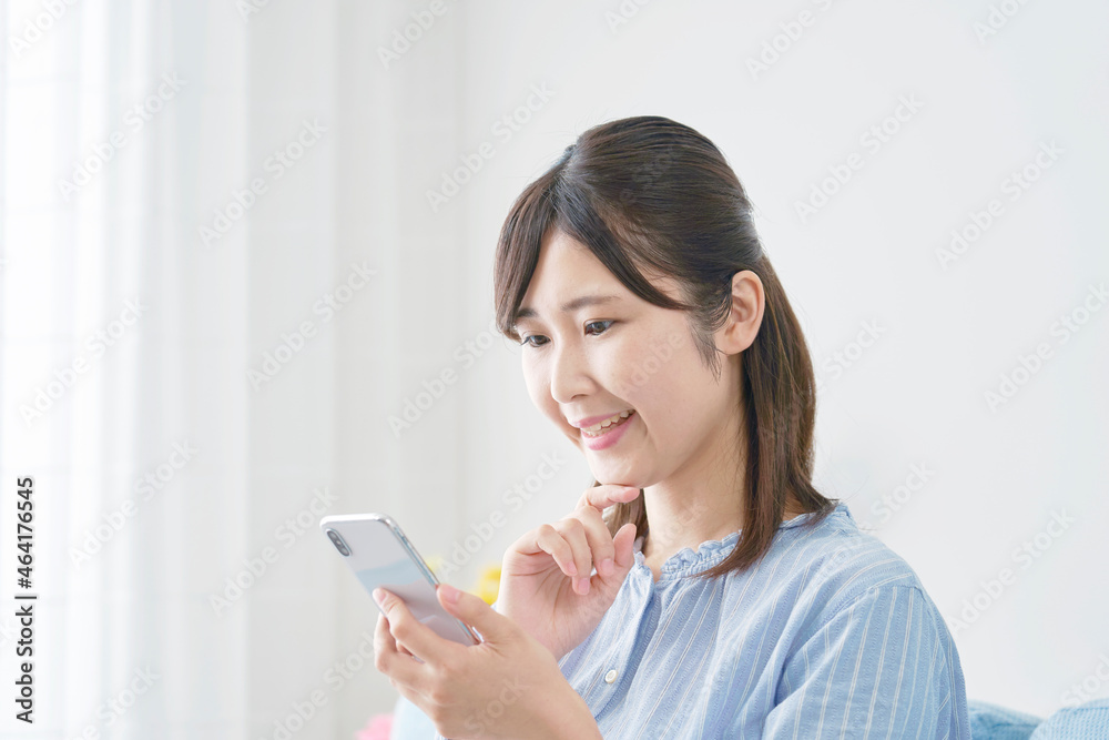 部屋でスマホを使う女性　考える