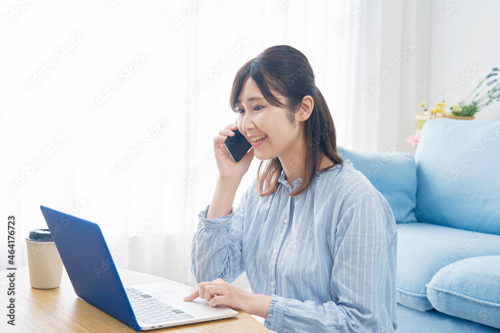 部屋で電話する女性