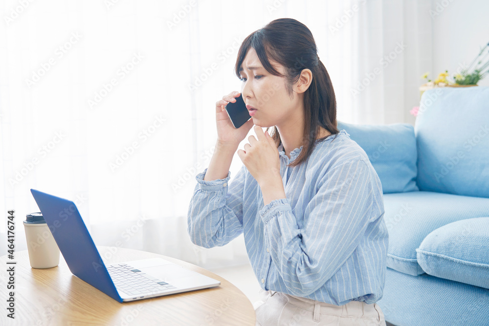 部屋で電話する女性